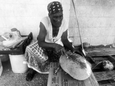 Market Lady Dar cutting jackfruit at the market in Hellshire Park on Saturday November 29th, 2025 Woman at market cutting jackfruit