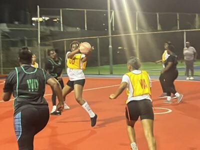 Goal Defense for the South Camp Road Rebels in a game against World Ward 1 catches the ball at center third at the Scotia sports club during Sutherland SPICE Netball Competition on December 12th, 2025 Girl catches a ball during netball came wearing white shirt and black shorts with yellow bib